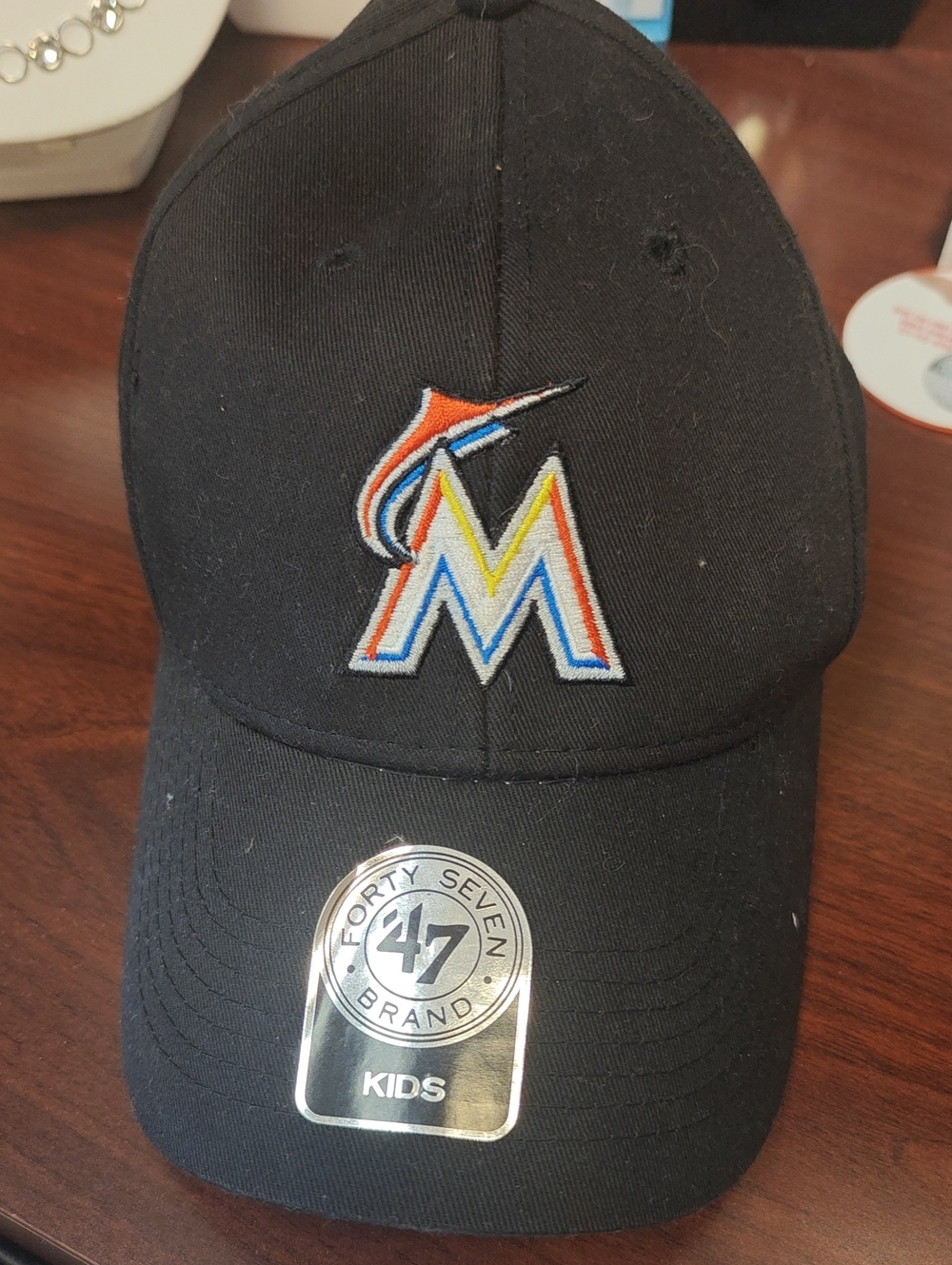 Genuine Merchandise Black Baseball Cap with White Logo Tag